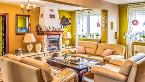 A living room with a fireplace, leather sofas, and a television. - Gorgeous home in Raciaz with WiFi (Raciaz)