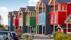 A row of colorful houses with a uniform architectural style, featuring gabled roofs and balconies. - Beach front home in Süssau/Ostsee with sauna (Süssau/Ostsee)