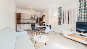 Eine moderne Wohnung mit Wohnzimmer, Essbereich und Küche.