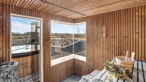 Un sauna aux murs en bois et aux grandes fenêtres.