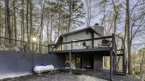 A two-story house with a balcony, surrounded by trees. - Lake, Fun, BBQ & Family. Charming & Cozy HOME! (morganton)