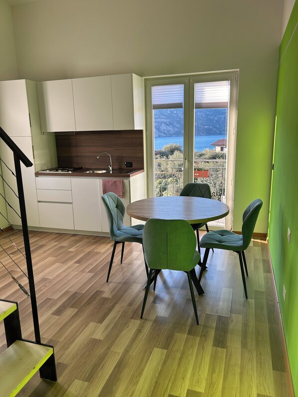 Eine moderne Küche mit weißen Schränken, einer Holzarbeitsplatte und Meerblick durch große Fenster.
