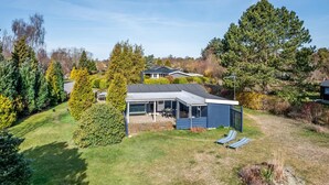 Une maison moderne dotée d’une grande terrasse et d’un patio couvert.