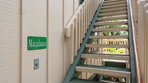 A staircase with a green sign reading "Macadamia" on the wall beside it. - 180' view 🌊& Mountain View! 1000 feet to 🏝watch 🌅 (Koloa)