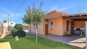 A two-story house with a tiled patio, a small garden, and a visible kitchen area. - Stunning home in Marina di Modica with WiFi (Marina di Modica)