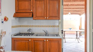 A kitchen with wooden cabinets, a gas stove, and a sink. - Stunning home in Marina di Modica with WiFi (Marina di Modica)