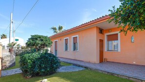 A single-story house with a red-tiled roof, a small front yard, and a paved driveway. - Stunning home in Marina di Modica with WiFi (Marina di Modica)