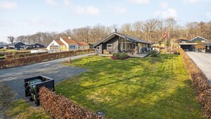 A modern house with a large deck and a well-maintained lawn. - Beautiful home in Juelsminde with WiFi (Horsens)
