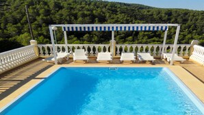A rectangular pool with white lounge chairs arranged around it, a pergola with a striped awning, and a white balustrade. - Beautiful home in La Font den Carros (La Font den Carros)