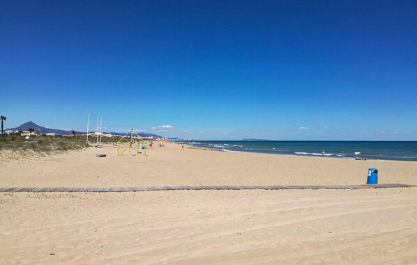 Enjoy a serene beach experience with a clear view of the surrounding mountains.
