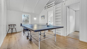 A ping pong table in a room with wooden flooring, white walls, and a sloped ceiling. - Lovely home in Hornbæk with WiFi (Hornbæk)