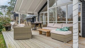 A covered outdoor seating area with wicker furniture, a wooden table, and a sofa. - Lovely home in Hornbæk with WiFi (Hornbæk)