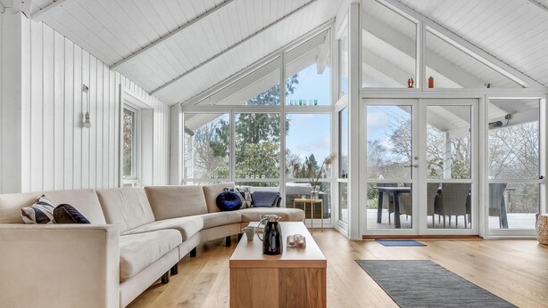 A spacious living room with a large window, a wooden coffee table, and a beige sofa. - Lovely home in Hornbæk with WiFi (Hornbæk)