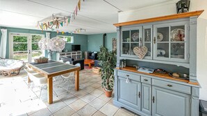 A spacious room with a dining table, chairs, a cabinet with glass doors, and a potted plant. - Cozy home in Makkum with kitchen (Makkum)