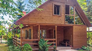 Eine Holzhütte mit Veranda und mehreren Fenstern.