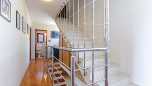 Een moderne trap met metalen leuningen en een houten vloer die uitkomt op een plateau.