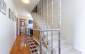 Stairs lead to an upper level with a window and framed pictures.