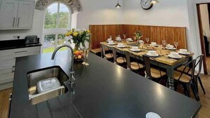 A spacious kitchen with a large island, wooden beams, and a skylight. - Amazing Chapel near Yr Wyddfa (Snowdon) and Zip World (Llanrug)