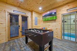 Relax in this room with a foosball table and large screen displaying scenic views.
