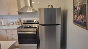 Een keuken met roestvrijstalen apparatuur, waaronder een oven en een koelkast.
