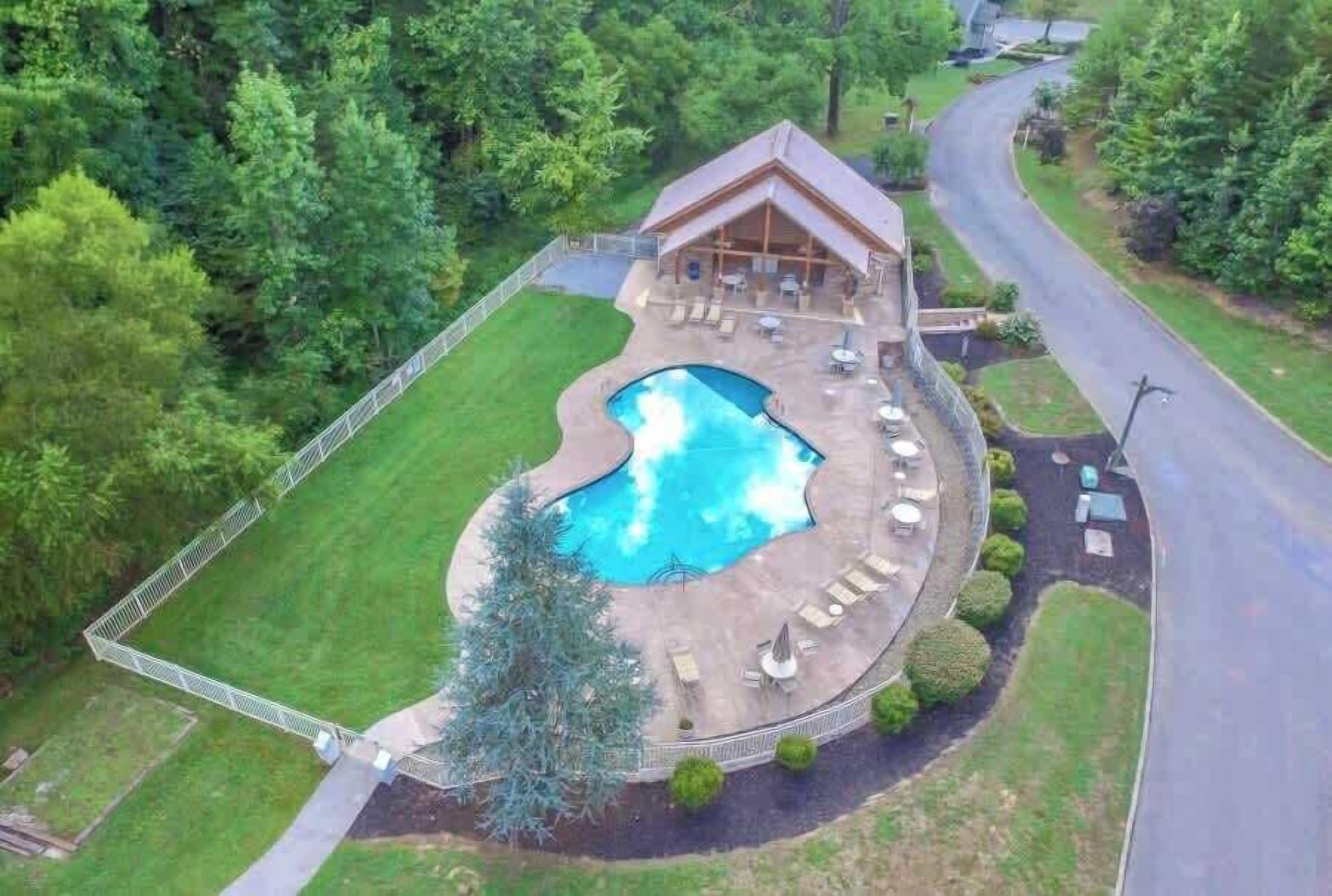 A house with a swimming pool, a covered patio, and a fenced yard.