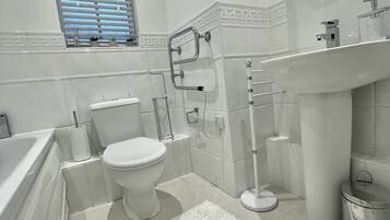 Bathtub, hair dryer, towels, toilet paper