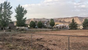 A residential area with houses, a fenced field, and mountains in the background. - #1 Large sunny room perfect for relaxing (St. George)