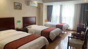 Ein Hotelzimmer mit zwei Betten, einem Schreibtisch, einem Stuhl und einem Fenster mit Vorhängen.