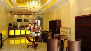 Eine Hotlellobby mit einer Rezeption, einer Chandelier und Sitzbereichen.