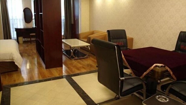 Ein Hotelzimmer mit Bett, Schreibtisch, Sofa und Esstisch.