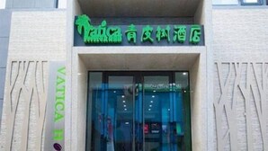 A hotel entrance with a sign in a foreign language, a glass door, and a textured facade. - Vatica Chaoyang the East of Railway Station Xinhua Road Hotel (Chaoyang)