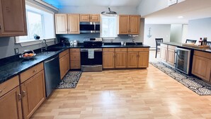 A modern kitchen with wooden cabinets, stainless steel appliances, and a herringbone-patterned floor. - Great location! Short walk to the beach, 5min drive to center! A lot of capacity (Jamestown)