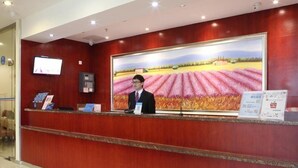 Un comptoir d’accueil orné d’un grand tableau représentant un champ et une personne au loin.