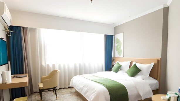 A hotel room with a large bed, a desk with a chair, a small table, and a large window with curtains. - Greentree Inn Jiangsu Changzhou Zhonglou District Qingfeng Park Express Hotel (Changzhou)