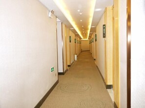 A hotel corridor with doors marked with room numbers, a carpeted floor, and a ceiling with recessed lighting. - Greentree Inn Chizhou Dongzhi County Lishan Xiushui Express Hotel (Chizhou)