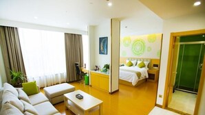 Una habitación de hotel moderna con sala de estar, kitchenette y dormitorio.