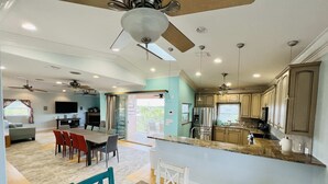 Un vaste espace de vie comprenant une table à manger, des chaises et un ventilateur de plafond.