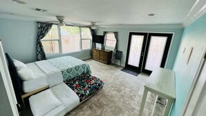 Une chambre à coucher avec un lit, un bureau, une chaise et une fenêtre.