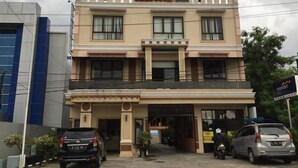 A hotel with a two-story facade, a balcony on the second floor, and a signboard above the entrance. - Belitong Inn Hotel Belitung (Tanjung Pandan)