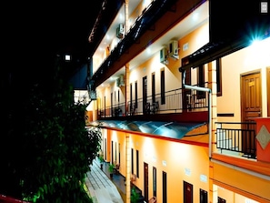 Un hôtel à plusieurs étages doté de balcons, de climatiseurs et d’un escalier.