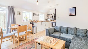 A modern apartment with a dining area, kitchen, and living room.