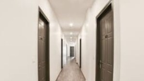 A long, narrow hallway with doors on both sides, leading to a room at the end. - DBR Suites, Sarjapur Road (Bengaluru)
