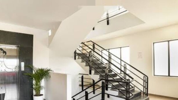 A modern interior with a staircase, a potted plant, and a large window. - DBR Suites, Sarjapur Road (Bengaluru)