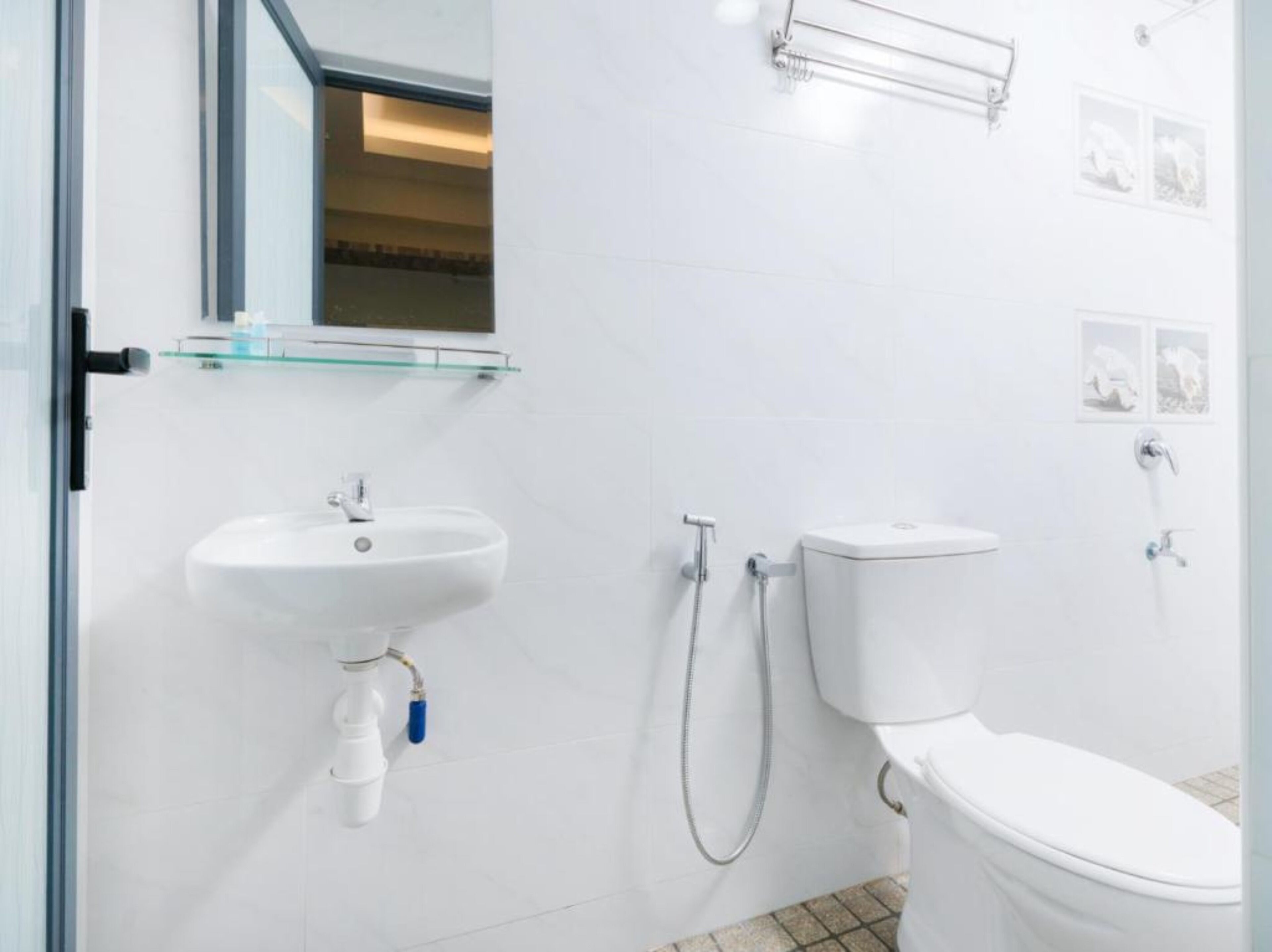 Un baño moderno con lavamanos, inodoro y ducha blancos.
