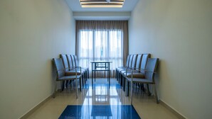 A hotel room with a ceiling fan, a large window with curtains, two chairs, and a small table. - Hope Hotel Masai (Masai)