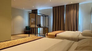 A hotel room with two beds, a desk with a chair, a wardrobe, and a large window with curtains. - Hope Hotel Masai (Masai)