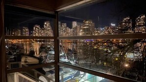 A multi-story building with a view of a city skyline at night. - Vancouver Waterfront 1480SF 2BR Townhome with Deck at Heather Civic Marina (Vancouver)