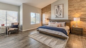 A bedroom with a large bed, two bedside tables, a chair, and a window with blinds. - Nintendo Super Mario Bros Castle in Scottsdale  (Scottsdale)