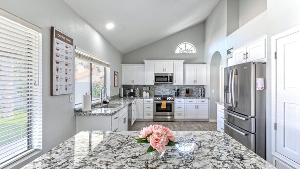 A modern kitchen with white cabinets, a granite countertop, and stainless steel appliances. - Nintendo Super Mario Bros Castle in Scottsdale  (Scottsdale)