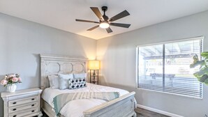 A bedroom with a bed, nightstand, lamp, ceiling fan, and window with blinds. - Nintendo Super Mario Bros Castle in Scottsdale  (Scottsdale)